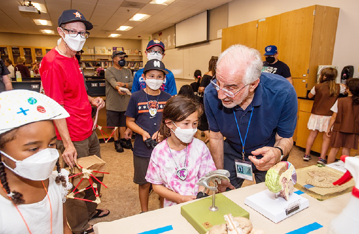 Mohsen Janatpour, professor of physics and astronomy at CSM and Family Science Day’s founder, explains models of the human brain to young visitors at the 2022 event