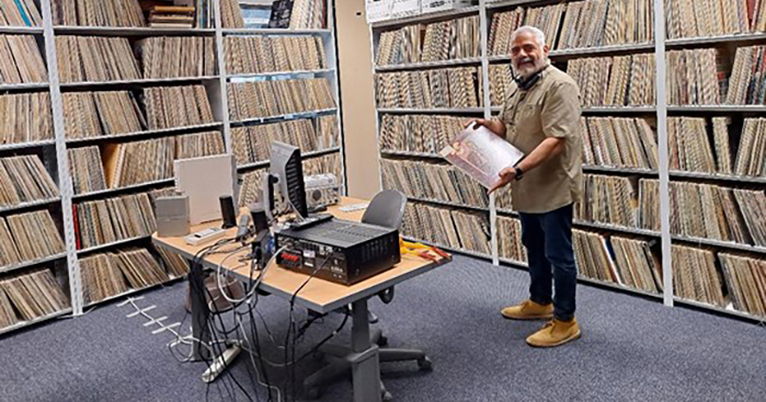 Current KCSM-FM general manager Dante Betteo shows off the station’s music library