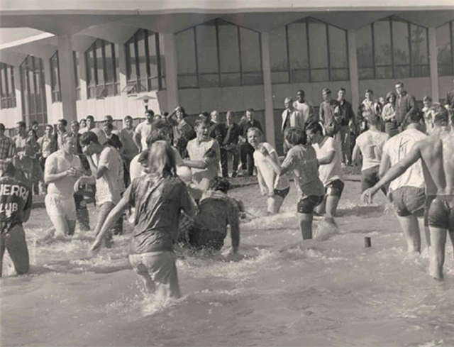 Students splash in the central plaza fountain, probably during the 1970s